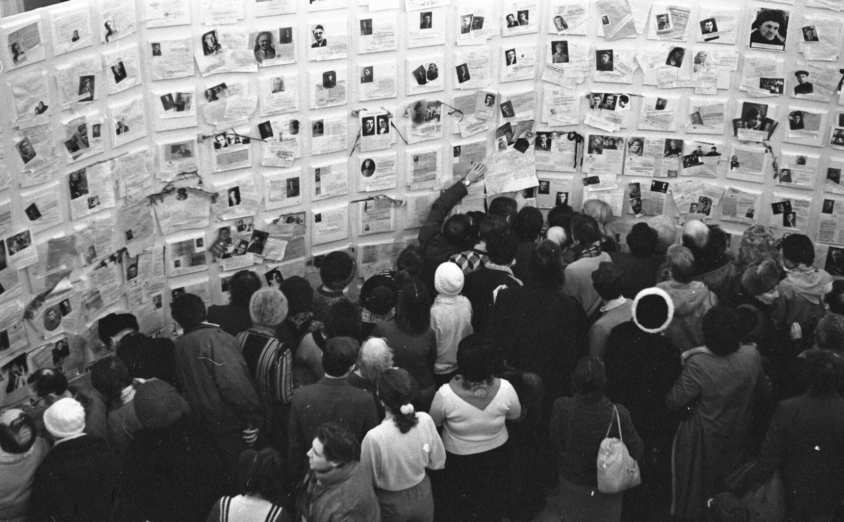 le persone guardano il muro di dolore con le immagini e i dati delle vittime di repressioni staliniane